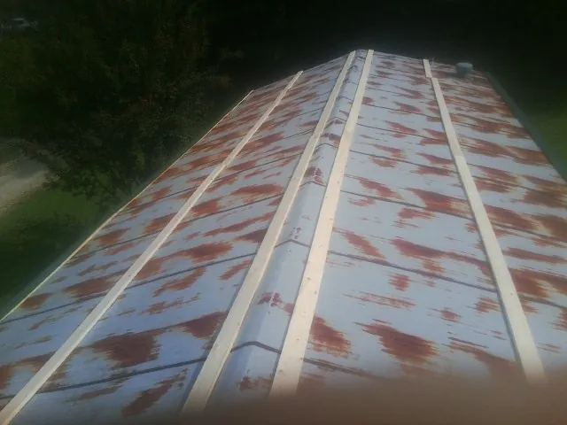 Rusted metal roof panels with new wood purlins before replacement — Storm Damage Roof Repair in Kelly by Roofing Brothers